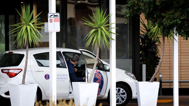 A pathology employee is seen arriving at the Melbourne Airport Holiday Inn. Picture: NCA NewsWire / Andrew Henshaw