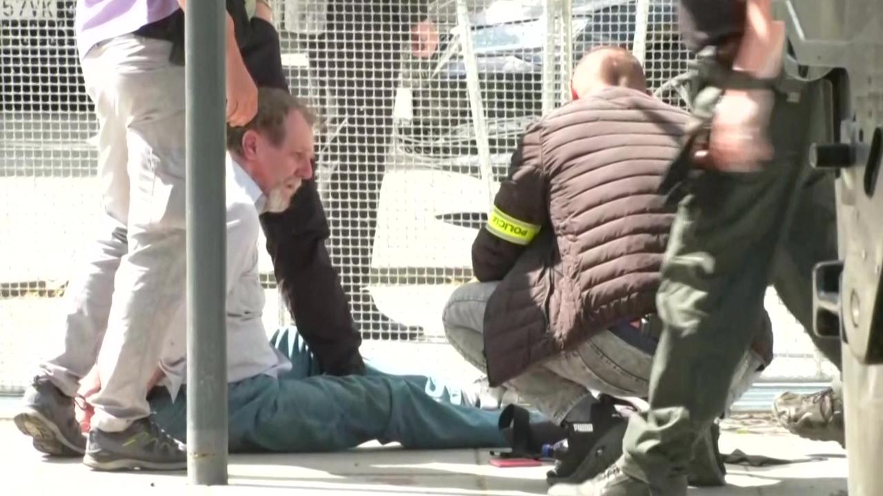 This image taken from video footage obtained by AFPTV shows security personnel apprehending a suspected gunman. (Photo by RTVS / AFP)