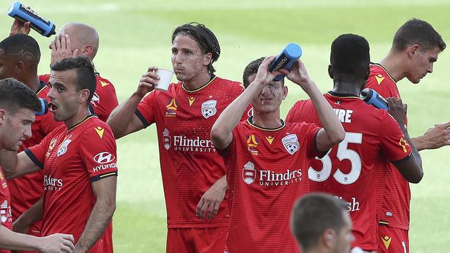 Adelaide United players take a drinks break at a sweltering Coopers Stadium. Picture: Sarah Reed