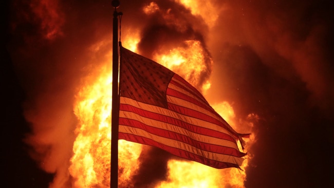 A flag flies in front of a department of corrections building after it was set ablaze during a second night of rioting on August 24, 2020 in Kenosha, Wisconsin. Picture: Getty