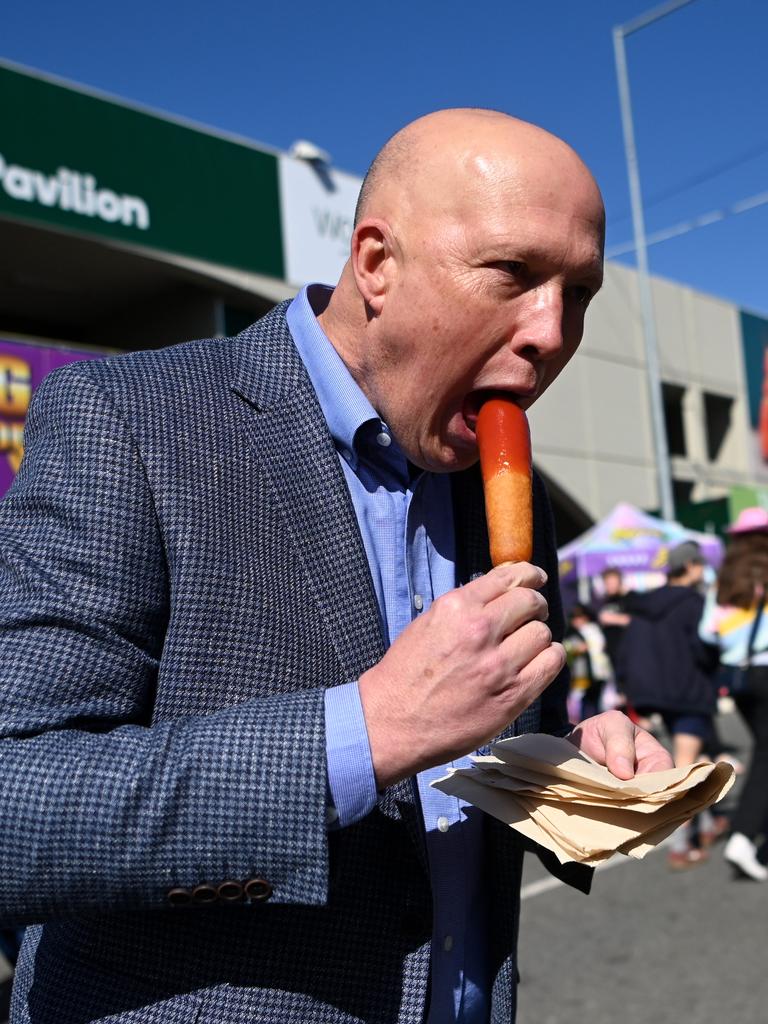 Mr Dutton chows down on a dagwood dog at the Ekka show. Picture: NCA NewsWire / Dan Peled