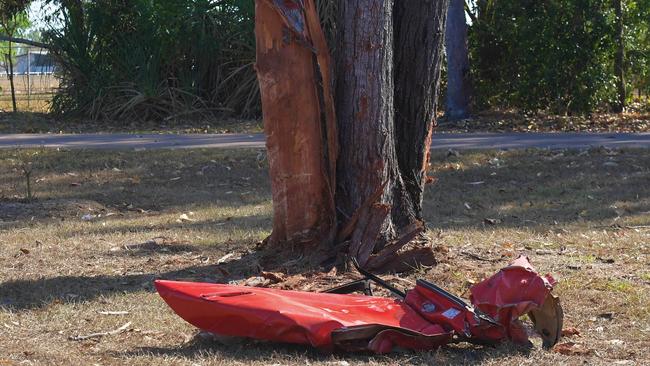 Part of the V6 Holden Commodore sits crumpled next to a tree near the Stuart Highway fatal crash