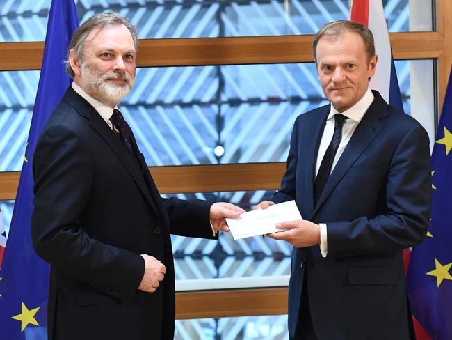 TOPSHOT - Britain's ambassador to the EU Tim Barrow delivers British Prime Minister Theresa May's formal notice of the UK's intention to leave the bloc under Article 50 of the EU's Lisbon Treaty to European Council President Donald Tusk in Brussels on March 29, 2017.  Britain formally launches the process for leaving the European Union on Wednesday, a historic step that has divided the country and thrown into question the future of the European unity project. / AFP PHOTO / POOL / Emmanuel DUNAND