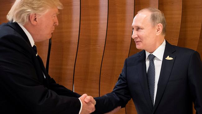 Donald Trump shakes hands with Vladimir Putin.