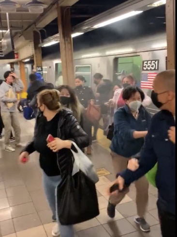Dozens of passengers pour out of a packed subway train in New York City after a gunman released a smoke grenade and opened fire. Picture: Twitter