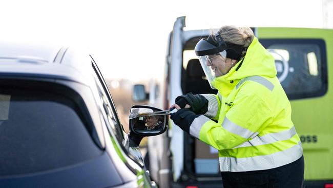 A staff member collects the last Covid-19 PCR tests at the Covid testing site. Picture: AFP.