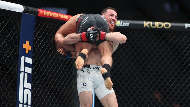 Merab Dvalishvili picks up Henry Cejudo in their bantamweight weight fight. Photo: M. Haffey/Getty Images/AFP.