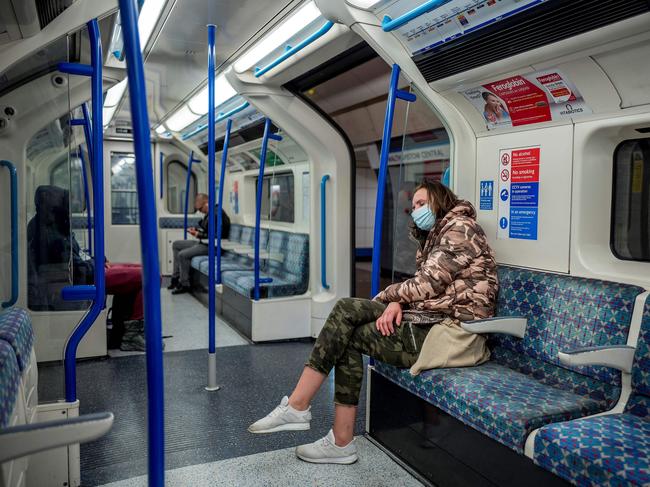 Commuters wear PPE (personal protective equipment), including a face mask as a precautionary measure against COVID-19, travel on a TfL (Transport for London) victoria line underground train towards central London. Picture: AFP