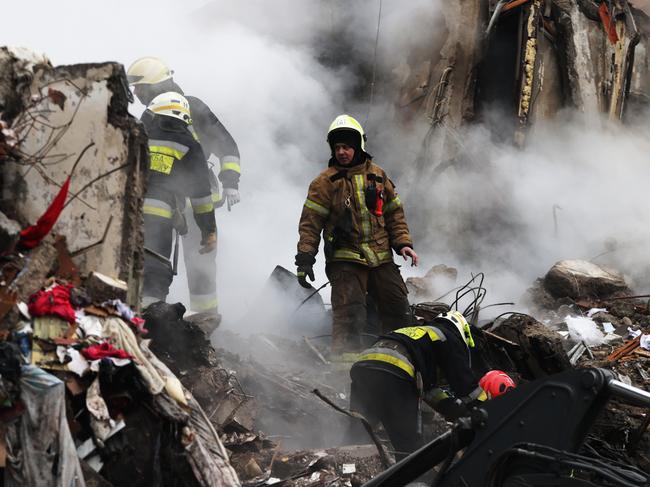 DNIPRO, UKRAINE - JANUARY 15: Emergency workers search the remains of a residential building that was struck by a Russian missile yesterday on January 15, 2023 in Dnipro, Ukraine. At least 20 people were reported dead after a missile hit the apartment building on Saturday, part of fresh wave of missiles launched by Russia. The Ukrainian president said his forces shot down 20 of 30 missiles fired by Russia on Saturday. (Photo by Spencer Platt/Getty Images)