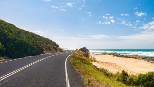 A sandy beach next to a section of the Great Ocean Road, near the town of Apollo Bay in Victoria State, Australia.