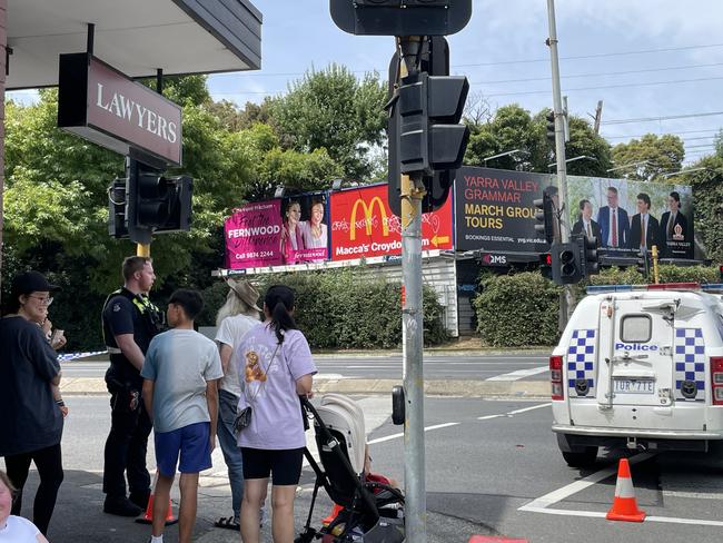 Bystanders talking to police following the shutdown of part of Maroondah Highway near Eastland due to a bomb threat. Picture: Kiel Egging.