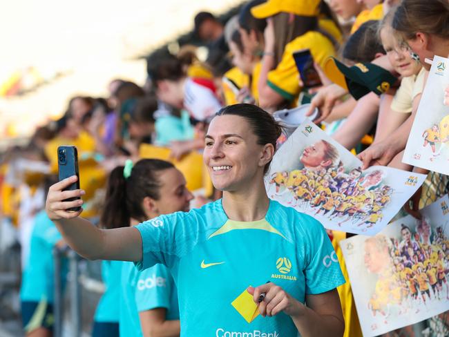 Steph Catley poses for a selfie with Matildas fans at an open training session in Brisbane. Picture: Adam Head