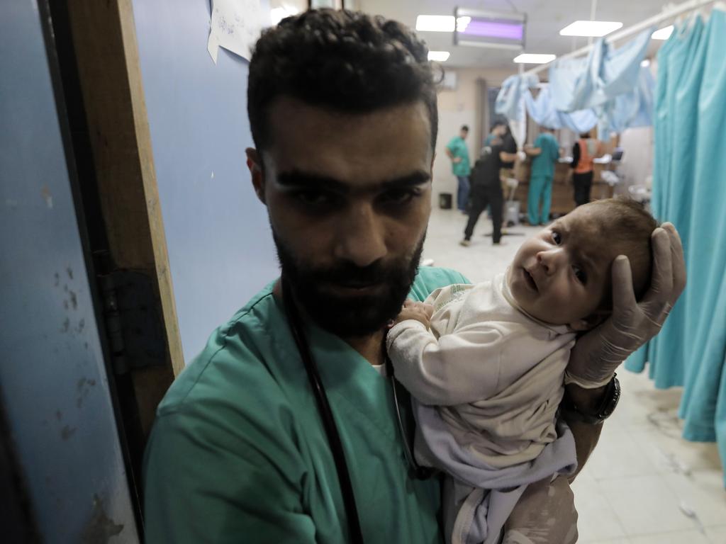 A medic carries a baby as Palestinians injured in air strikes arrive at Nasser Medical Hospital on November 18, 2023 in Khan Yunis, Gaza. Picture: Ahmad Hasaballah/Getty Images