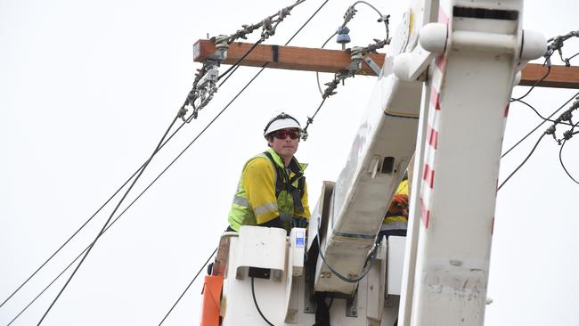 A linesman works to reconnect power. Picture: Lawrence Pinder