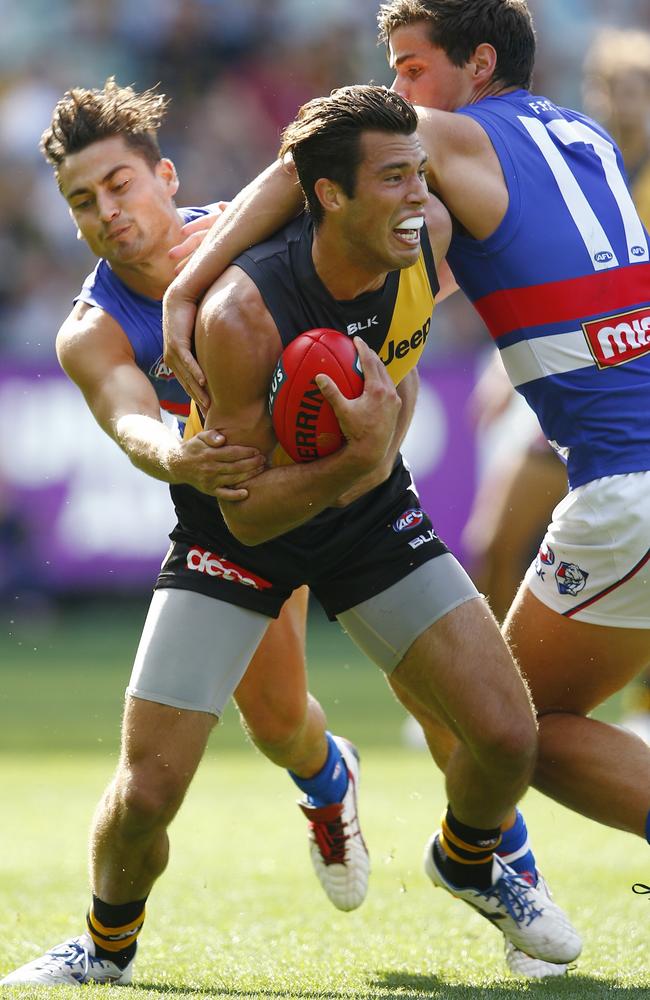 Alex Rance tries to break two Bulldog tackles. Picture: Michael Klein