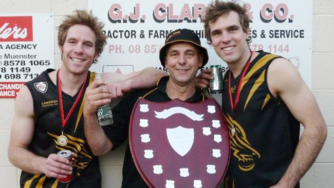 Ben Grieger, left, with his father Andrew and twin brother Ryan after winning a Lameroo premiership in 2009.