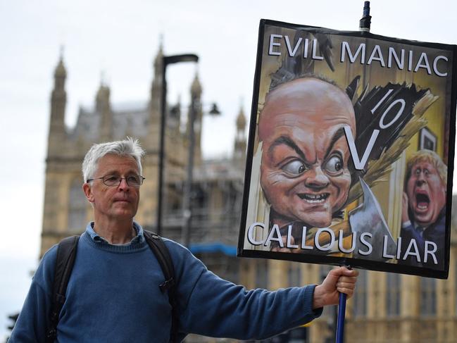 A demonstrator holds a placard showing former number 10 special adviser Dominic Cummings and Britain's Prime Minister Boris Johnson. Picture: AFP