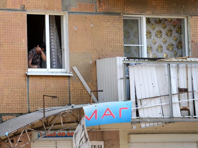 A woman reacts as she stands at her window with broken panes in downtown Donetsk. Picture: Francisco Leong