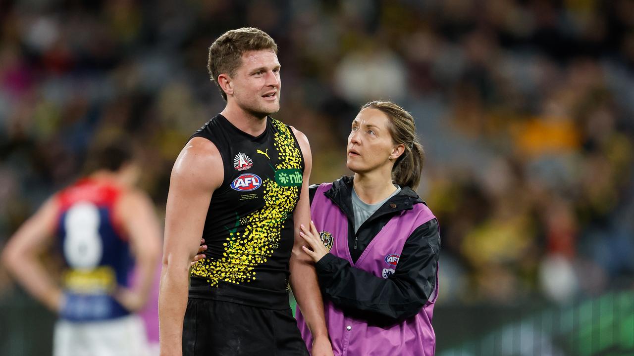 MELBOURNE, AUSTRALIA - APRIL 24: Jacob Hopper of the Tigers is seen to by medical staff during the 2024 AFL Round 07 match between the Richmond Tigers and the Melbourne Demons at the Melbourne Cricket Ground on April 24, 2024 in Melbourne, Australia. (Photo by Dylan Burns/AFL Photos via Getty Images)