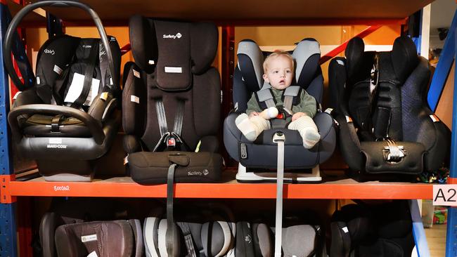 The Baby Give Back team are conducting a safety-check, cleaning and assessment of donated baby car seats. Little 9 month old Oakleigh Cotter has decided which is his favourite. Picture Glenn Hampson