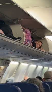 Woman sneaks into overhead compartment on flight