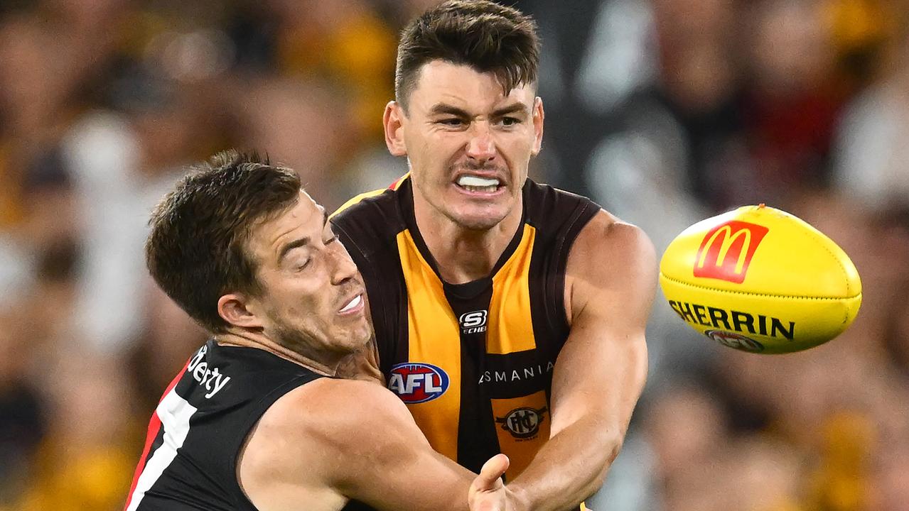 MELBOURNE, AUSTRALIA - MARCH 14: Josh Battle of the Hawks handballs whilst being tackled by Zach Merrett of the Bombers during the round one AFL match between Hawthorn Hawks and Essendon Bombers at Melbourne Cricket Ground, on March 14, 2025, in Melbourne, Australia. (Photo by Quinn Rooney/Getty Images)