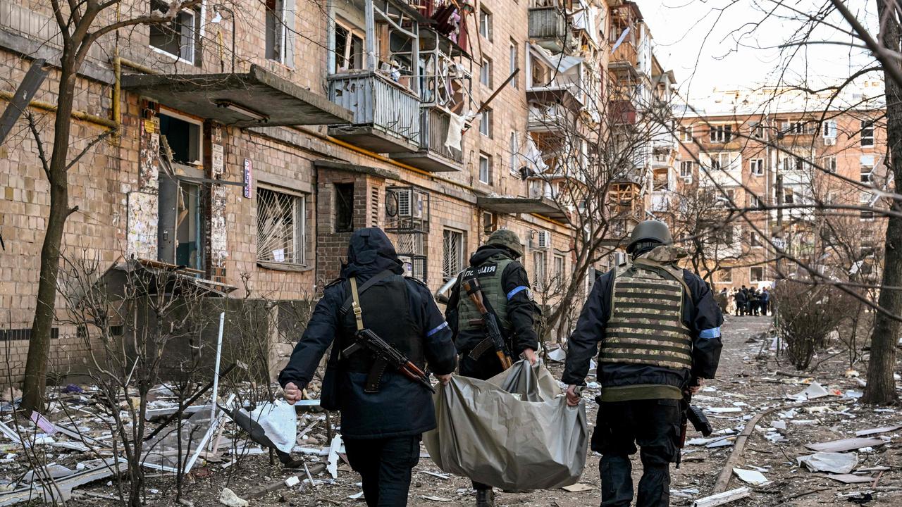 Ukrainian police carry a body away from a five-storey residential building that partially collapsed after a shelling in Kyiv. Picture: AFP.