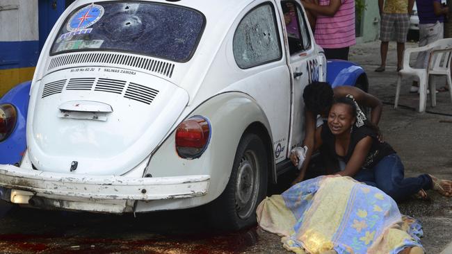 Relatives weep after gunmen opened fire on a taxi killing the driver and the passenger in the Pacific resort city of Acapulco in 2011. Picture: AP Photo/Bernandino Hernandez