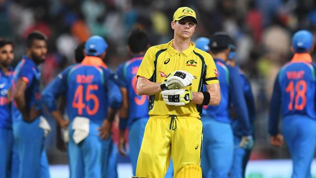 Australia's captain Steve Smith (C) reacts as Indian cricketers celebrate the wicket of Australia's Travis Head during the second one day international (ODI) match of the ongoing India-Australia cricket series at the Eden Gardens Cricket Stadium in Kolkata on September 21, 2017. / AFP PHOTO / Dibyangshu SARKAR / ----IMAGE RESTRICTED TO EDITORIAL USE — STRICTLY NO COMMERCIAL USE----- / GETTYOUT