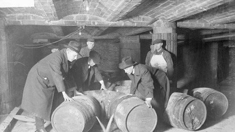 Police officers destroying barrels of alcohol during the 1920s Prohibition Era in the United States.