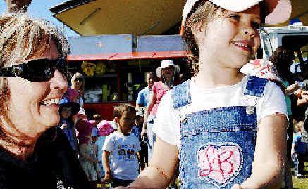 Eileen Wilton from the Lennox Head Rural Fire Service shows Sarah Mallam, 5, of Ballina the fire hose used by RFS crews.