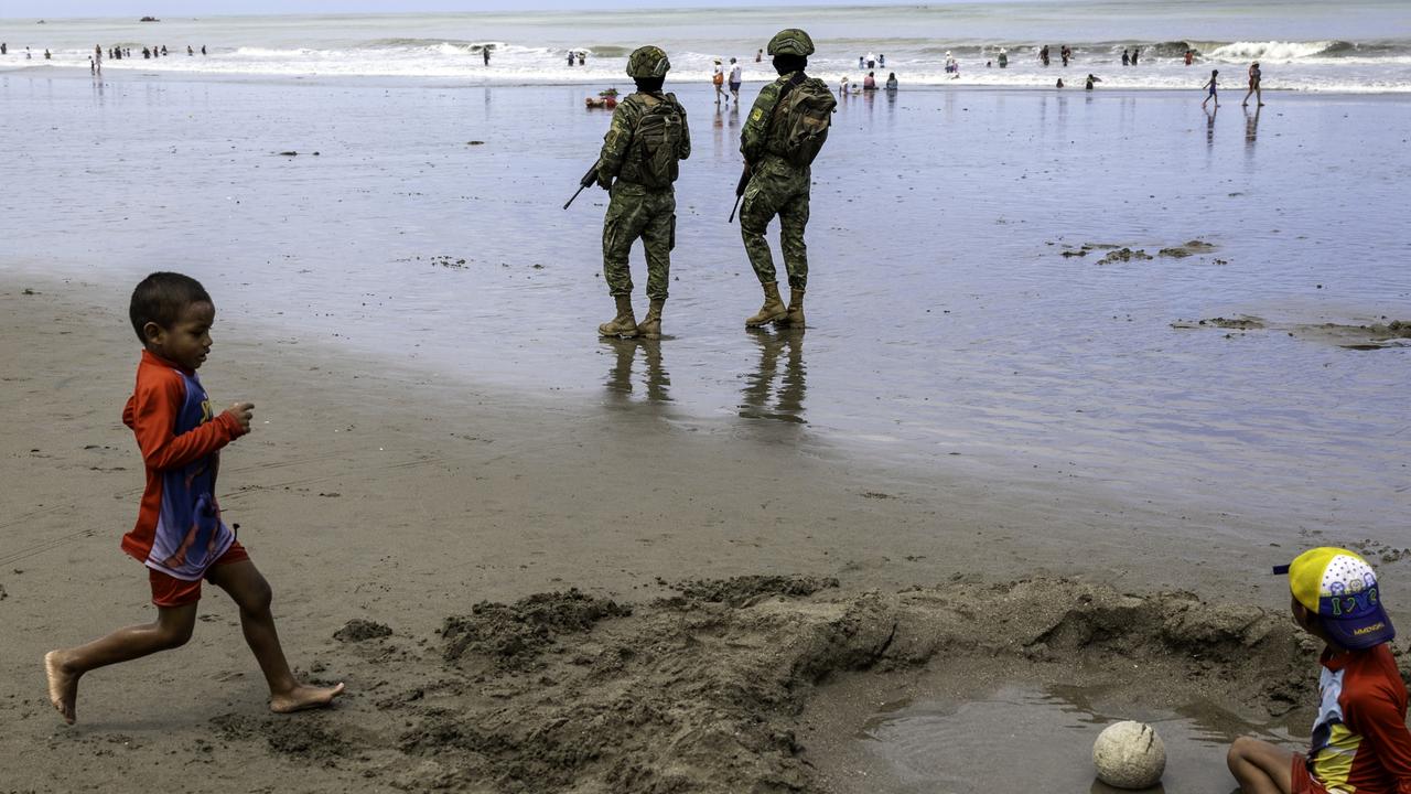 Soldiers stand guard as children play. Picture: John Moore/Getty Images