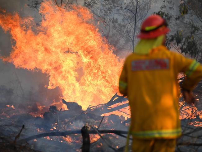 A firefighter defends a property in Torrington, near Glen Innes, on Sunday. Picture: AAP/Dan Peled