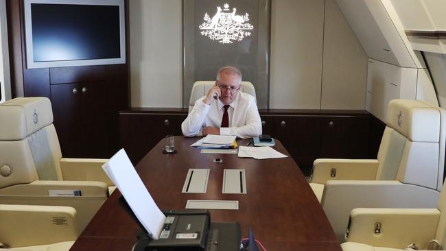 Scott Morrison takes a phone call inside ‘Shark One’, his $250m converted VIP plane. Picture: Adam Taylor