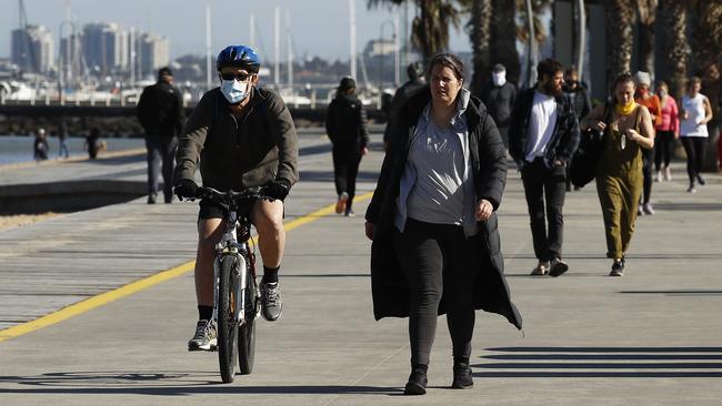 People enjoying exercise at St Kilda Beach during stage four restrictions. Picture: Daniel Pockett