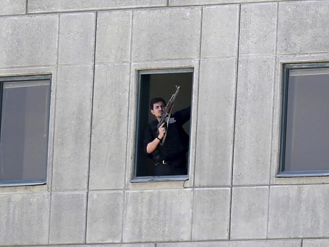 An armed man stands in a window of the parliament building in Tehran, Iran.  Several attackers stormed into Iran's parliament and a suicide bomber targeted the shrine of Ayatollah Ruhollah Khomeini. Picture: Fars News Agency, Omid Vahabzadeh via AP