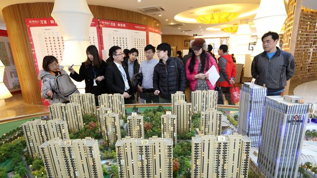 Visitors look at a model of residential buildings at the Fun City apartment complex, developed by China Vanke Co, in a showroom in Beijing. Picture: Tomohiro Ohsumi/Bloomberg