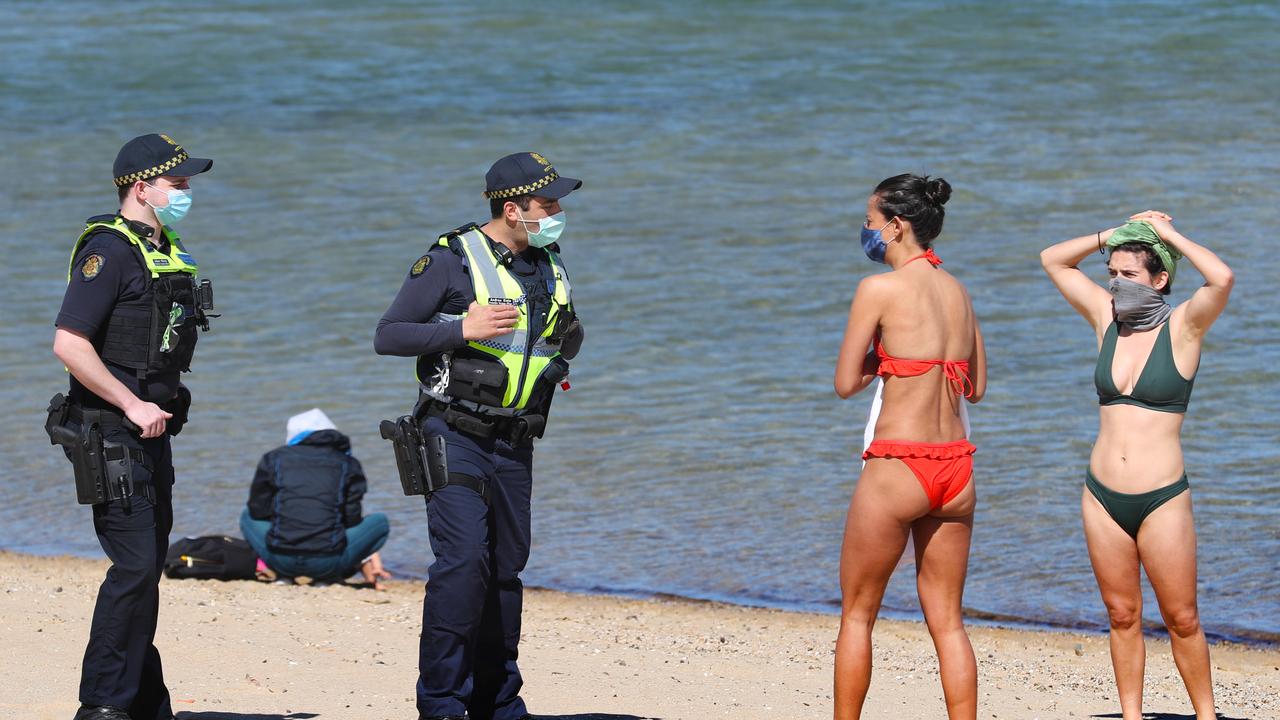 PSO officers speak to women on St Kilda beach. Picture: NCA NewsWire/David Crosling