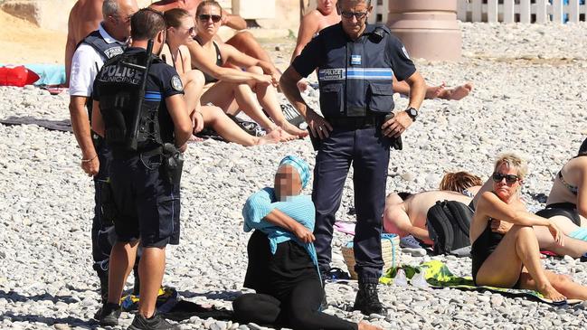 In 2016, 16 cities in France banned Islamic-inspired swimwear, sometimes known as the ‘burkini’. The ban was later found to be unlawful and overturned. Pictured are French police issue a ticket to a woman on a Nice beach. Picture: Vantagenews.com