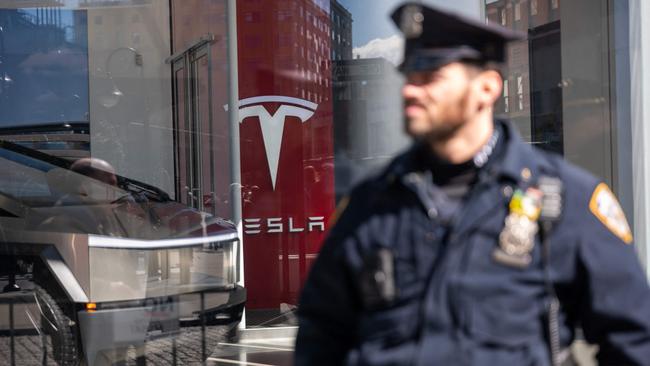 Police stand guard as protesters gather outside of a Manhattan Tesla dealership. Photo: Photo SPENCER PLATT / Getty Images