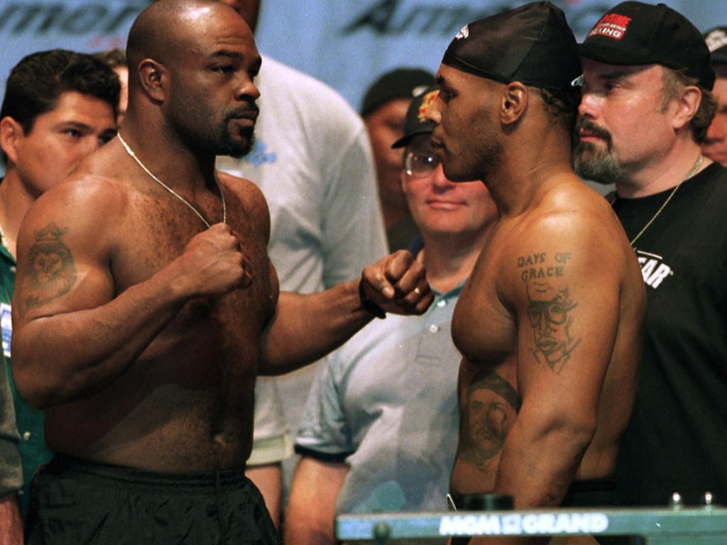 Former heavyweight champion Mike Tyson, right, poses with Orlin Norris at their 1999 weigh-in.