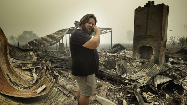 Josh Collings returns to his burnt home days after being cut off by the fire in Main St, Cudgewa. Picture: Tony Gough