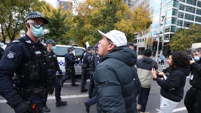 A protester screams at police during an anti-lockdown rally organised by a group dubbed Health Rights Alliance in Flagstaff Gardens in Melbourne on Saturday. Picture: Alex Coppel.