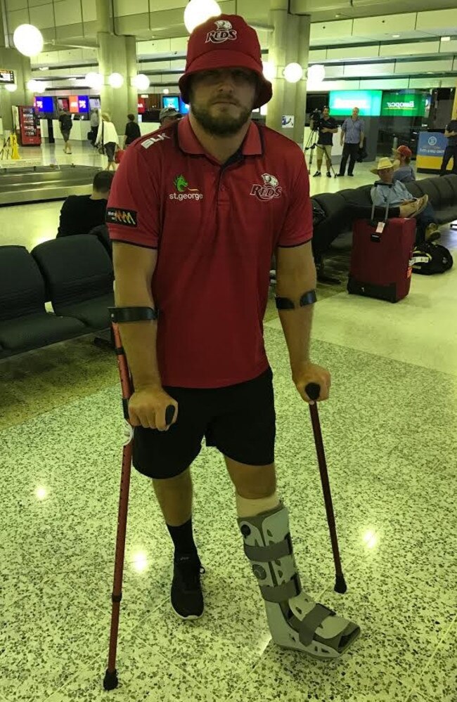 Reds skipper James Slipper returns home in a moonboot.