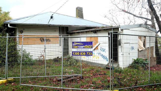 The house is behind temporary fencing, but a gap in the fence allows anyone to enter.