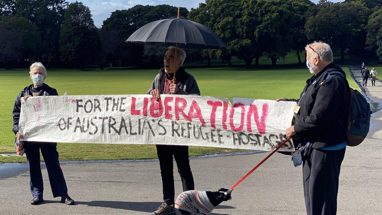 Two people held the banner and chanted about refugee rights before another man joined them (centre) and spoke about Julian Assange. Picture: NCA NewsWire/ Hannah Moore