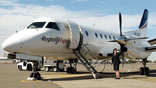 (FILES) A file photo taken on August 6, 2002, shows Captain Belinda Fleming standing in front of a Regional Express Airlines (REX) plane during the airline's launch at Sydney Airport. The regional Australian airline on March 20, 2017, grounded six planes from its fleet after a propeller fell off one of them as it approached Sydney airport. / AFP PHOTO / WILLIAM WEST