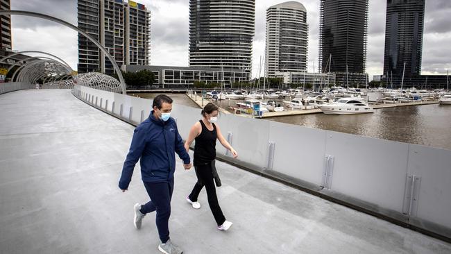 A couple exercising in Docklands on Sunday, after an announcement on restrictions easing was delayed. Picture: NCA NewsWire/David Geraghty