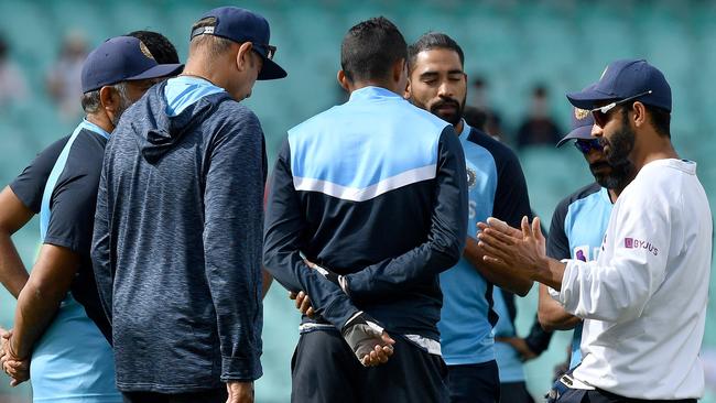 Indian captain Ajinkya Rahane, right, leads a team talk before play on day two. Picture: AFP