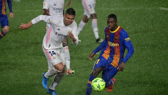 Real Madrid's Brazilian midfielder Casemiro (L) challenges Barcelona's French forward Ousmane Dembele during the "El Clasico" Spanish League football match between Real Madrid CF and FC Barcelona at the Alfredo di Stefano stadium in Valdebebas, on the outskirts of Madrid on April 10, 2021. (Photo by JAVIER SORIANO / AFP)